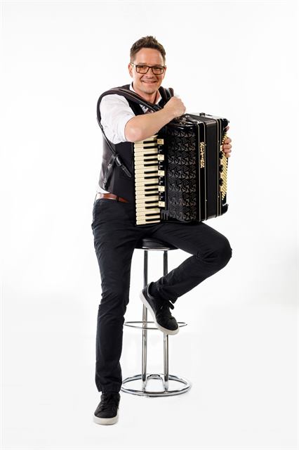 Andrej Švab s harmoniko na barskem stolu