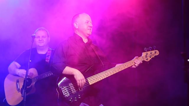 Kitarist in basist na odru v vijolični svetlobi